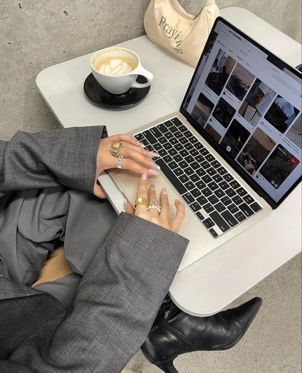 Notebook aberto com referências visuais e café sobre a mesa